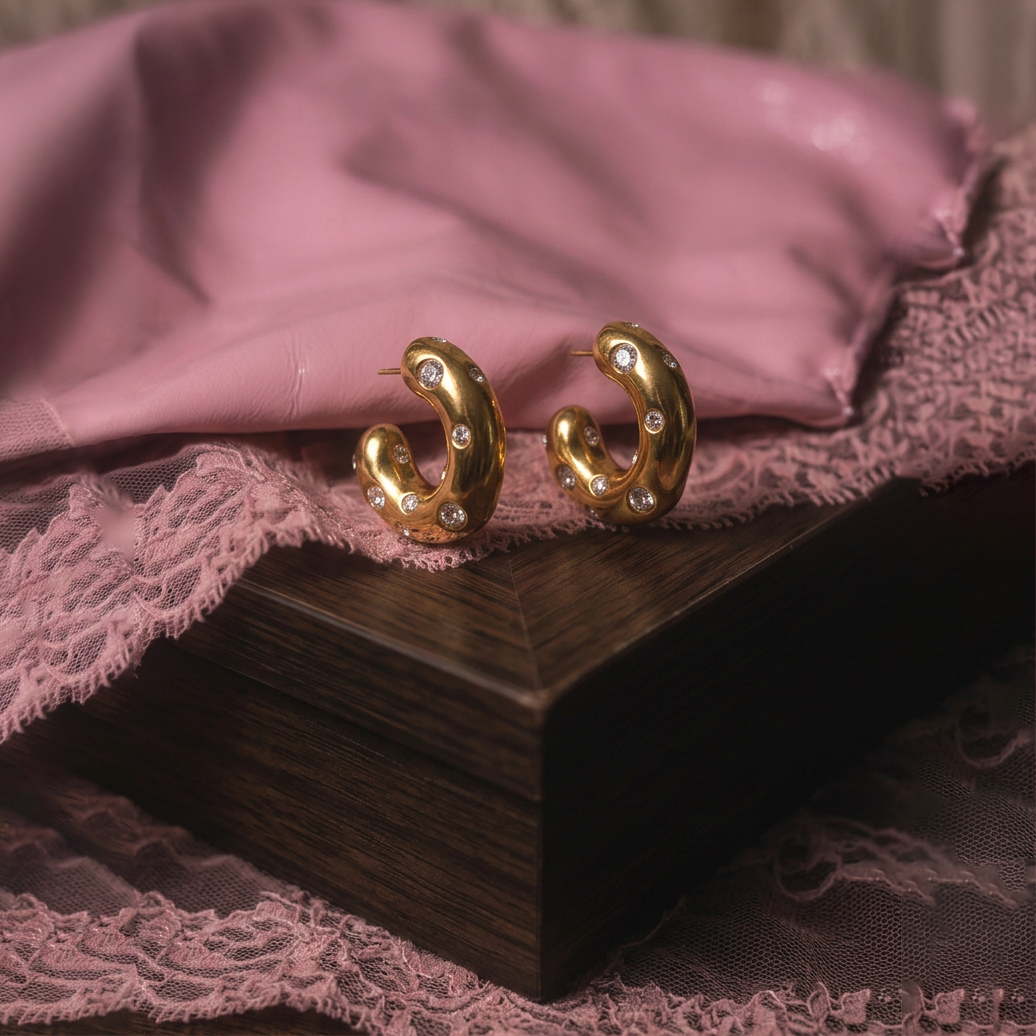 Chunky Spot crystal hoop earrings, a pair on a dark wooden box with pink lace and satin