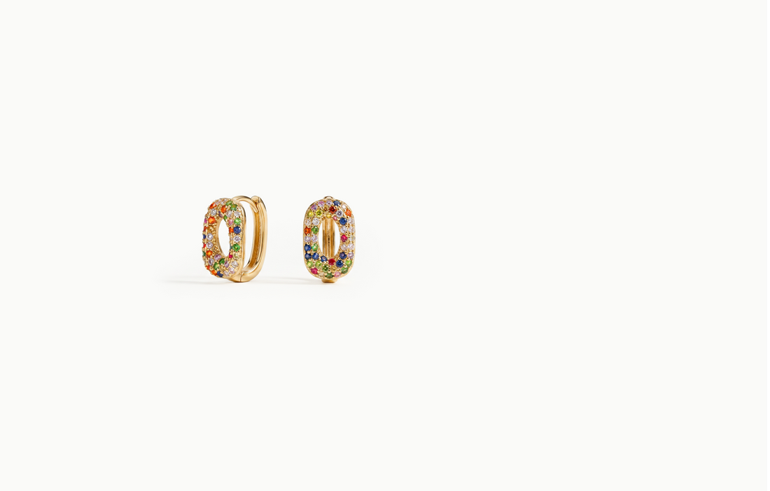 Oval gold hoop earrings covered in multicoloured crystals