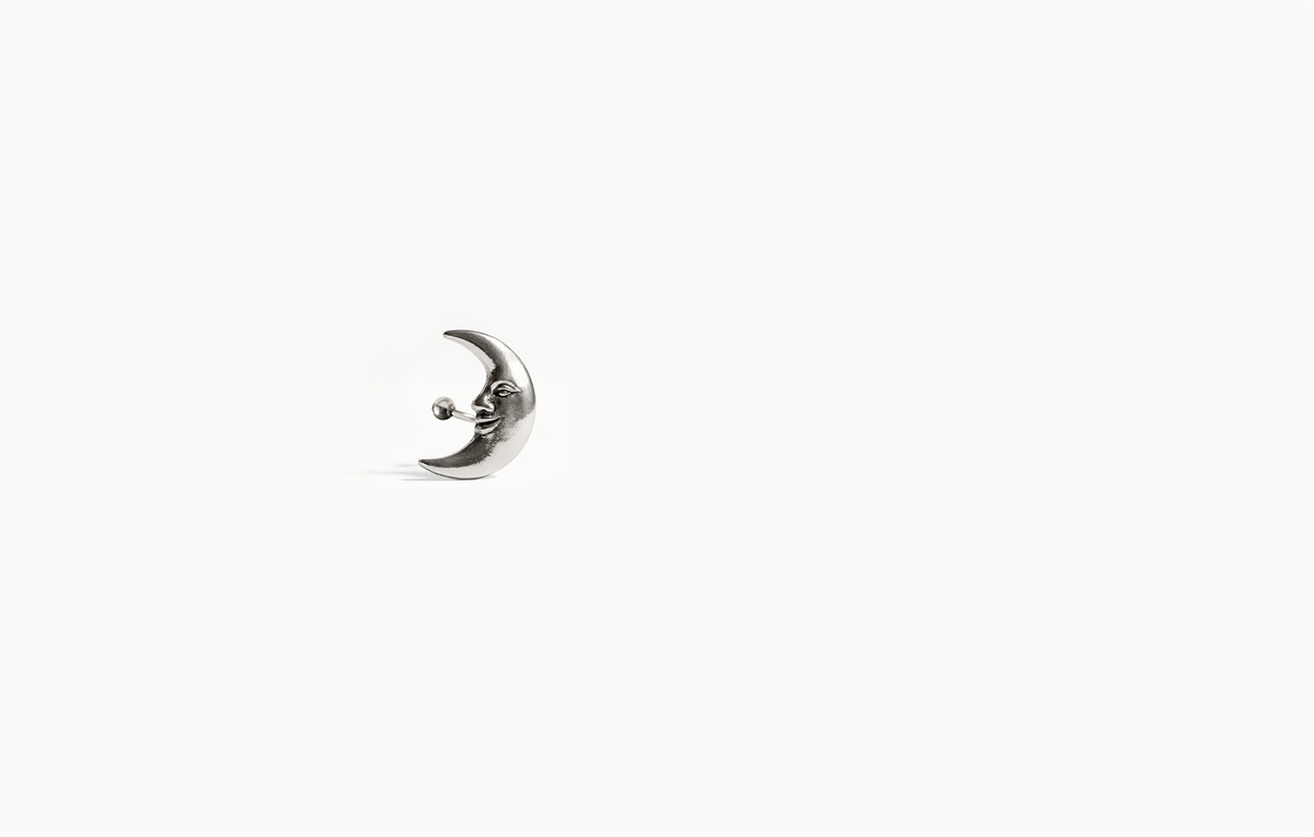 Silver crescent moon earring with a face