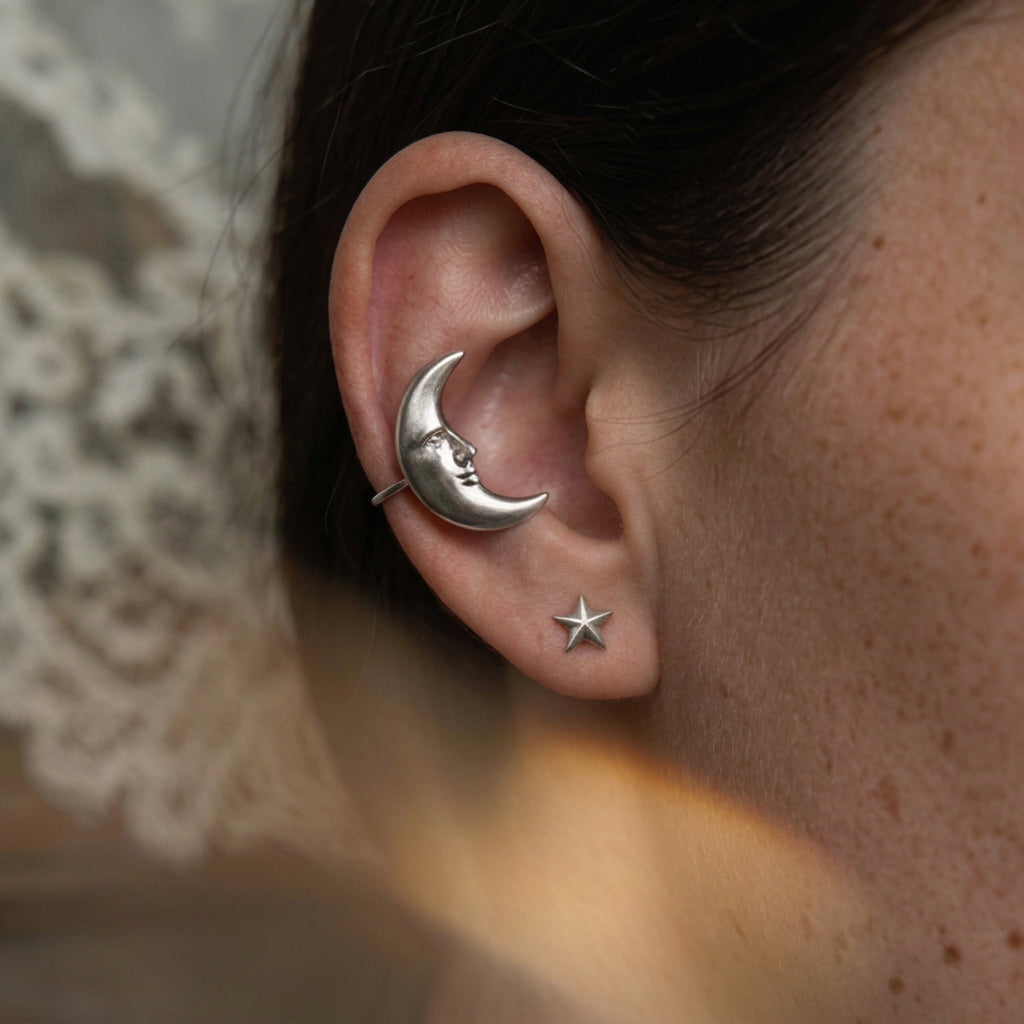 Goodnight Moon ear cuff worn on the upper ear, silver crescent moon with a face beside a small star stud