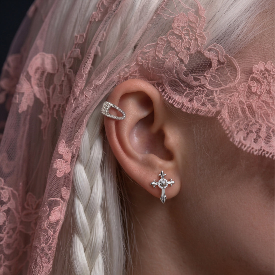 Crystal Hair-Clip ear cuff worn on the upper ear above a small cross stud, with white braided hair and pink lace