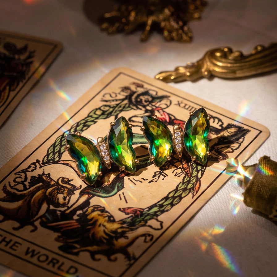 Absinthe Crystal Butterfly earrings, green and yellow crystal wings on a tarot card with gold ornaments