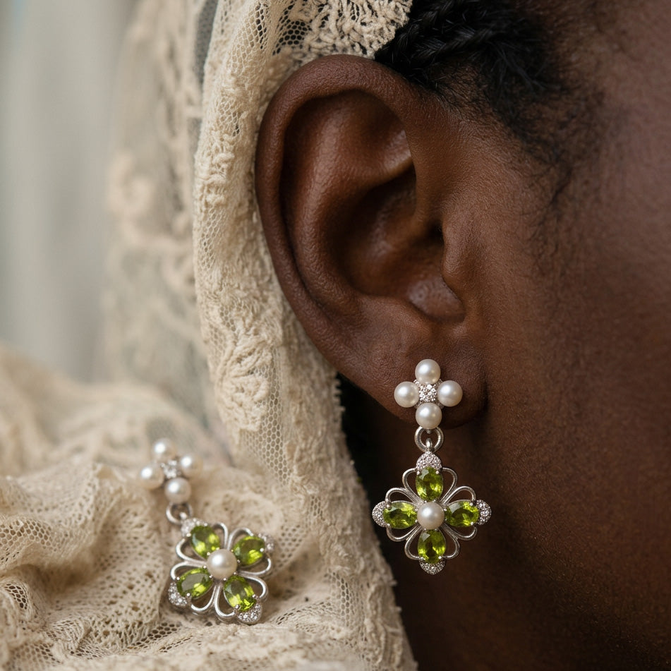 Victorian Crystal Drop earring worn on the ear, pearl cluster above a green jewel flower, cream lace behind