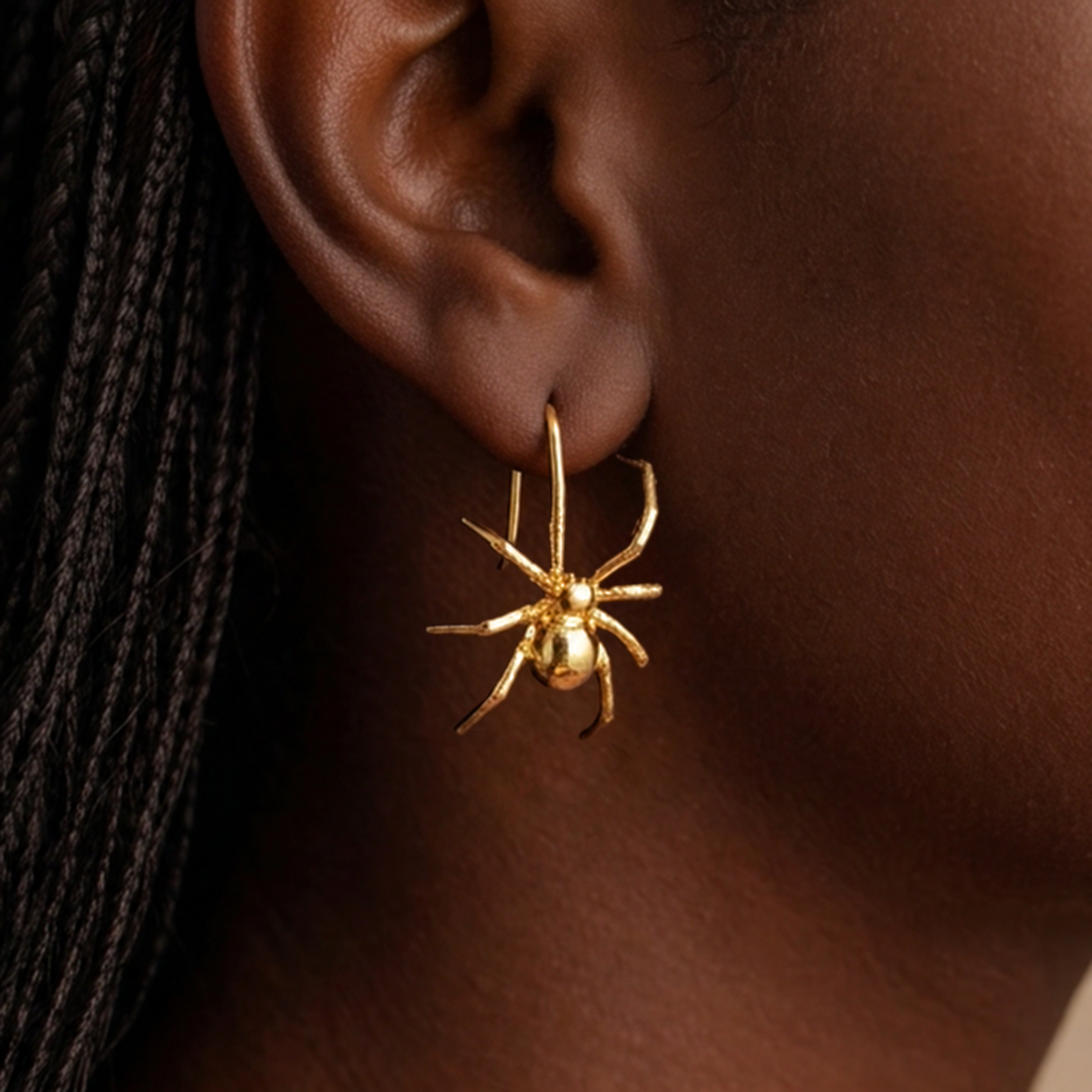 Long Legs Spider earrings worn on the ear, a gold spider hanging from an ear wire
