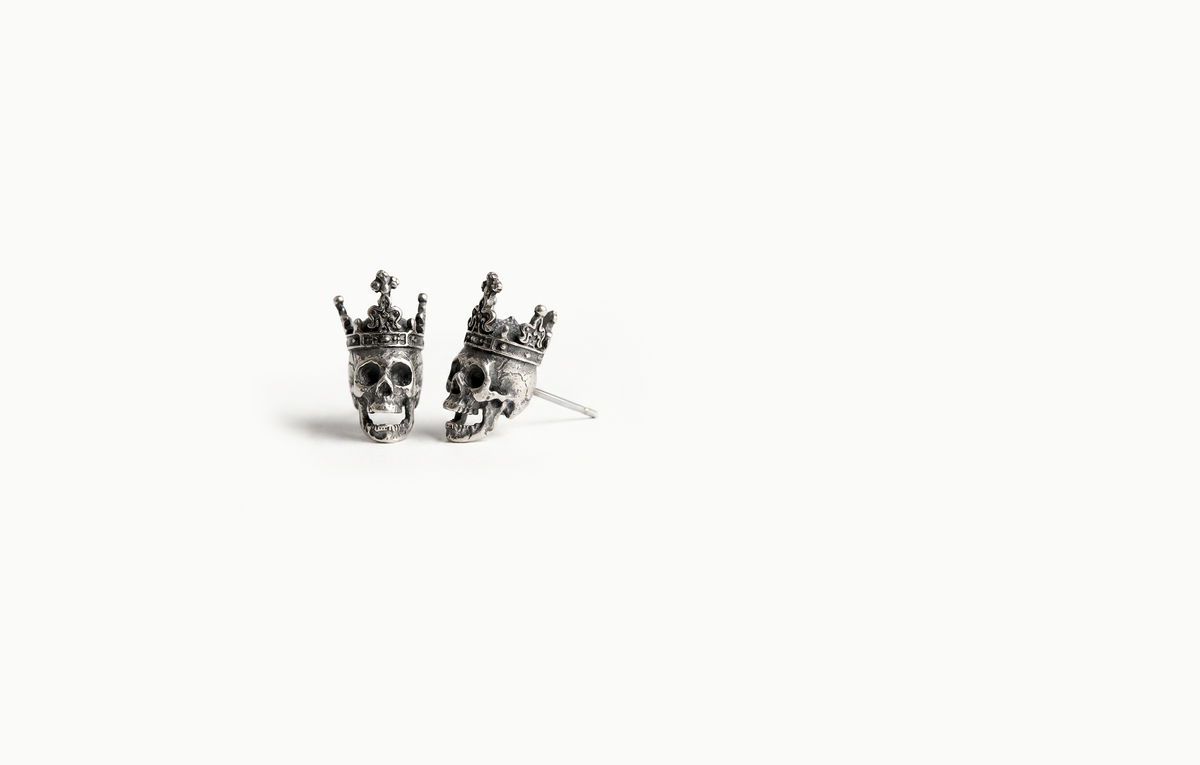 Silver skull stud earrings wearing crowns
