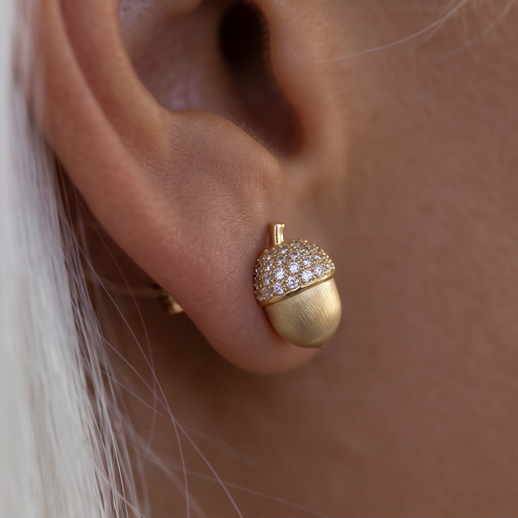 Crystal Acorn stud earrings, close-up of a gold acorn with a crystal cap worn on the ear