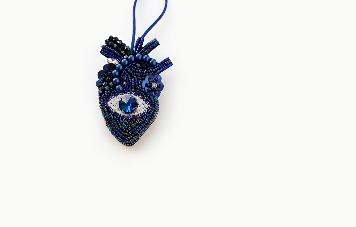 Navy beaded heart bag charm with a blue jewel eye