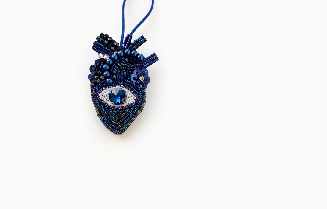 Navy beaded heart bag charm with a blue jewel eye