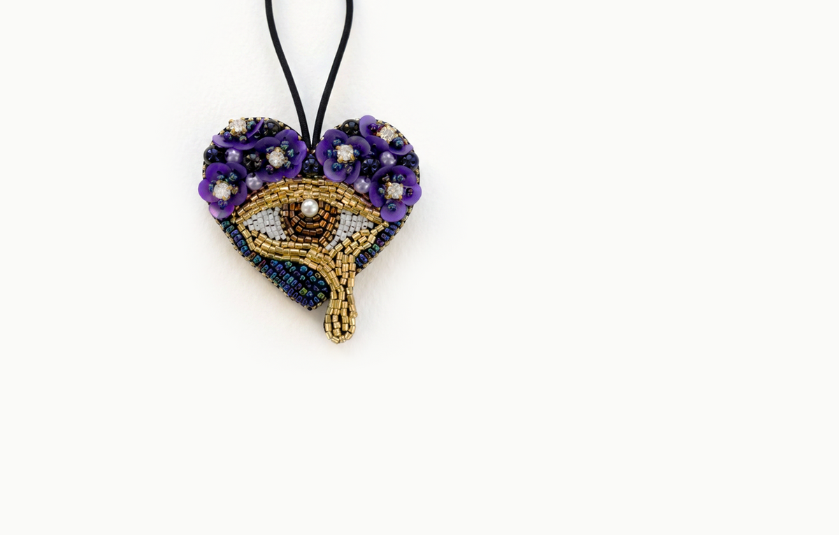 Beaded heart bag charm with an eye and purple flowers