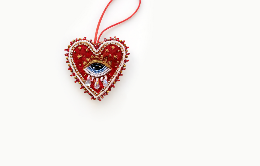 Red beaded heart bag charm with an eye