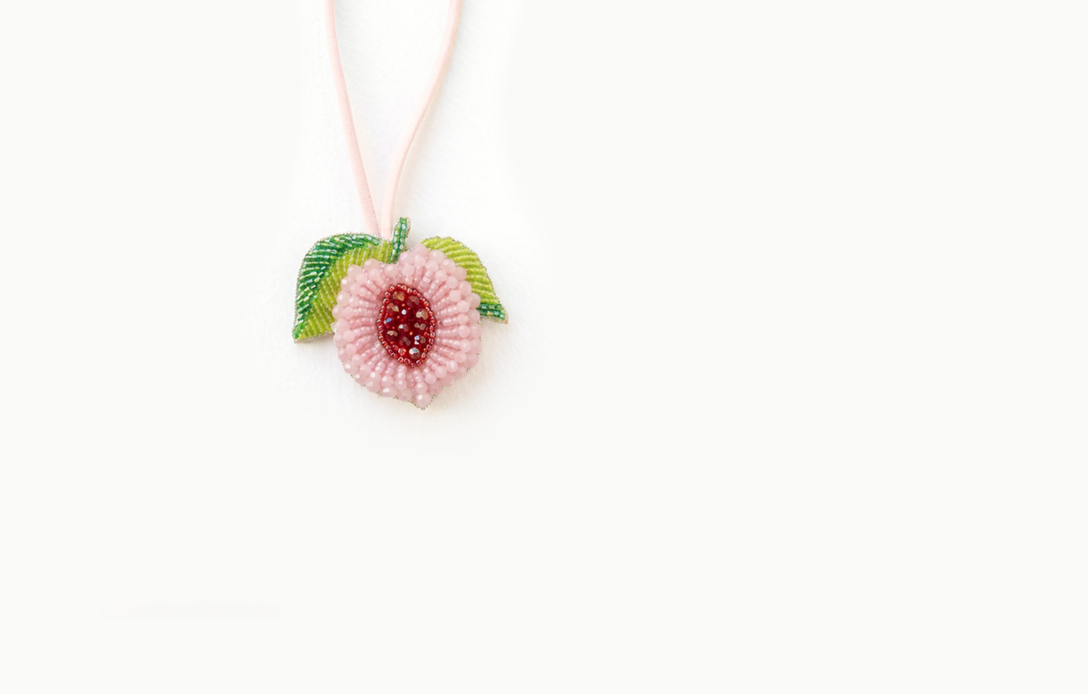 Pink beaded peach bag charm with green leaves