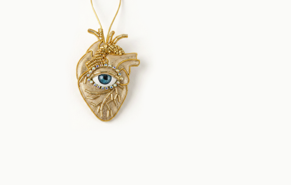 Gold beaded heart bag charm with a blue eye