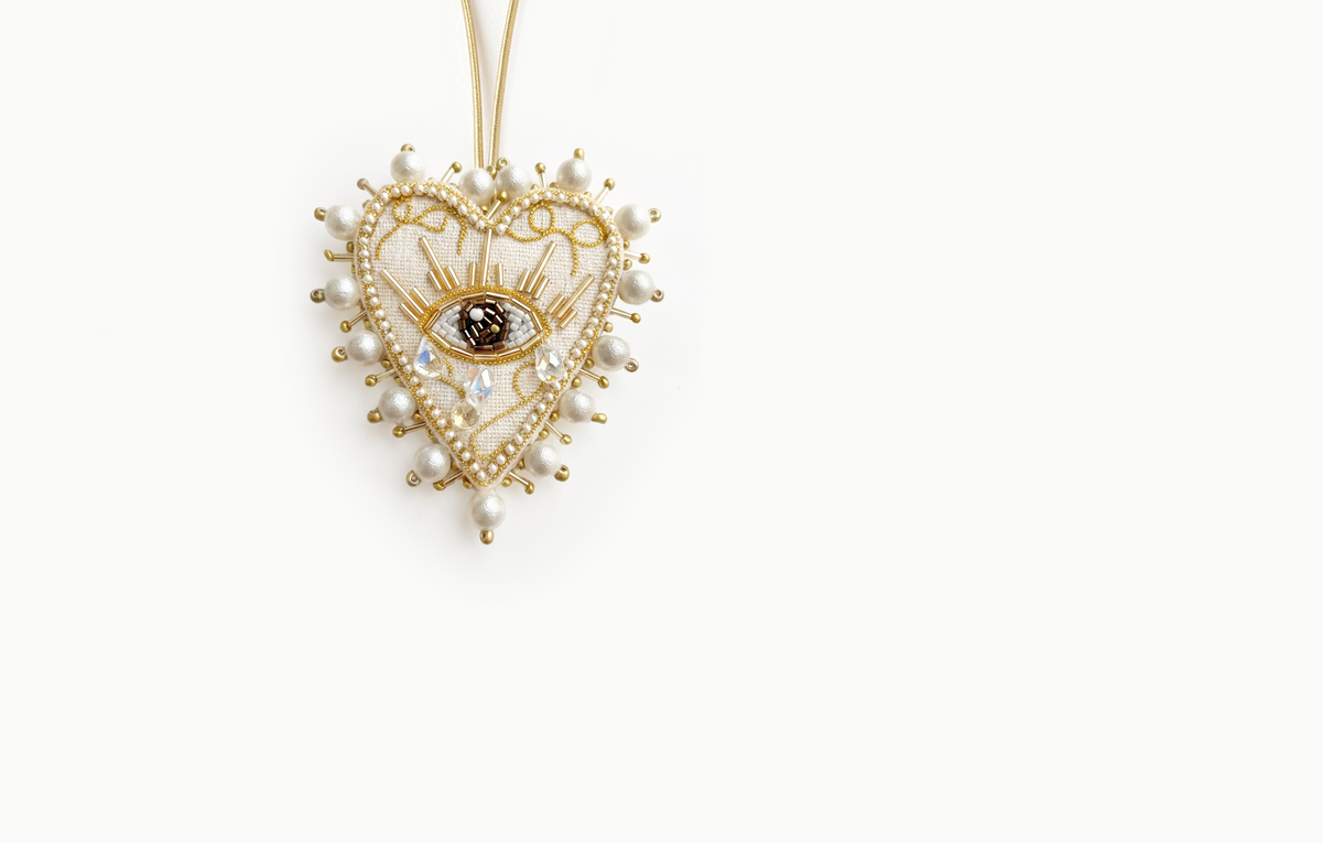 Ivory and gold beaded heart bag charm with an eye