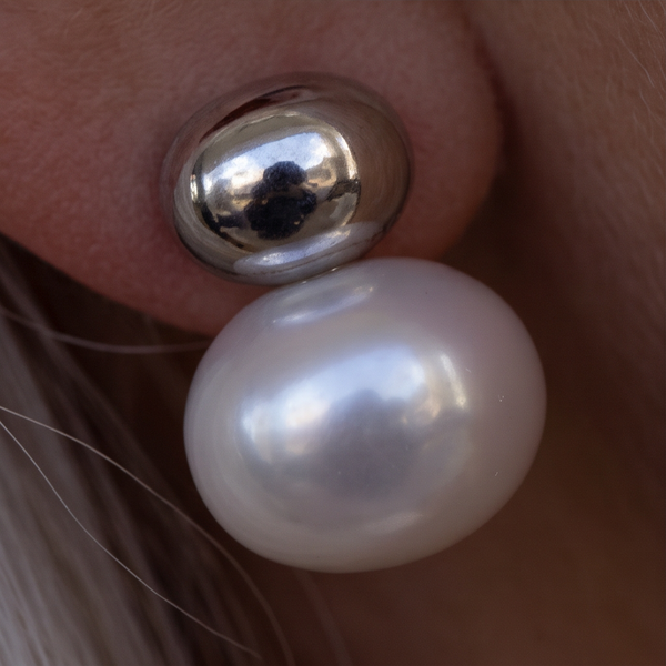 Silver Cap Pearl earrings, macro of a white pearl beneath a mirror-bright silver dome