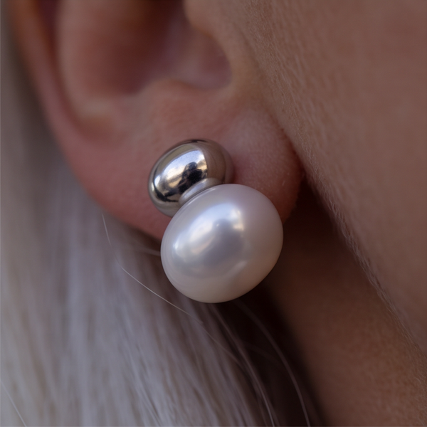 Silver Cap Pearl earrings worn on the ear, white pearl under a silver dome, light grey hair