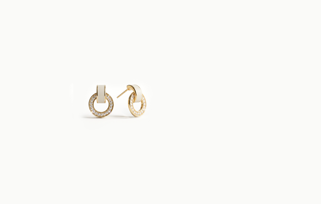 Gold crystal ring earrings hanging from a white link