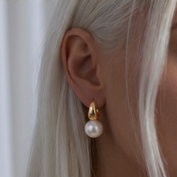 Classic Pearl drop earrings worn on the ear, gold curved top and white pearl, light grey hair