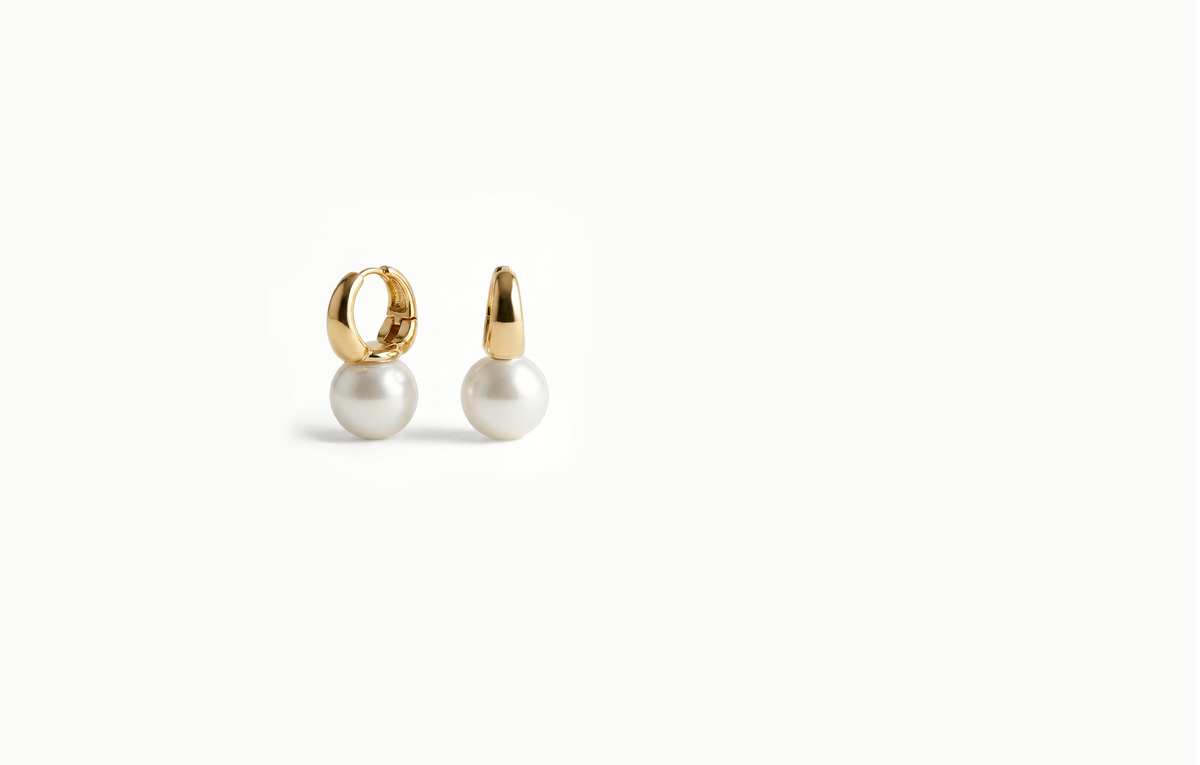 Gold drop earrings with a large pearl hanging from a bold hoop