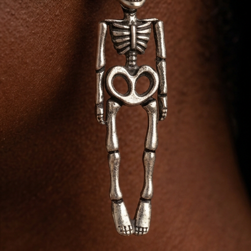 Hanging Skeleton earrings close-up, a full silver skeleton hanging below the ear