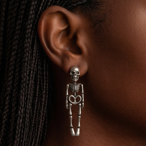 Hanging Skeleton earrings worn on the ear with braided hair, silver skull stud and dangling skeleton