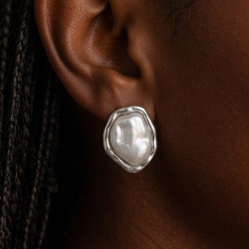 Baroque Pearl earrings worn on the ear, silver-framed white pearl, braided hair