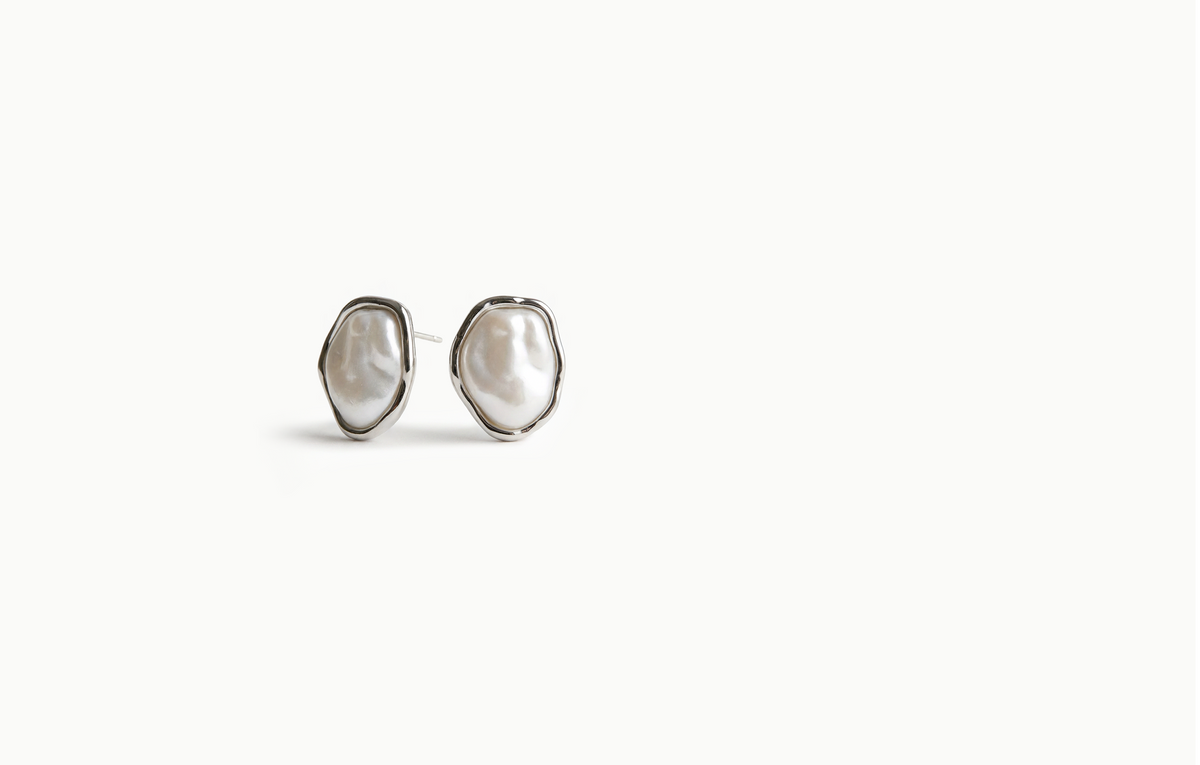 Irregular baroque pearl stud earrings framed in silver