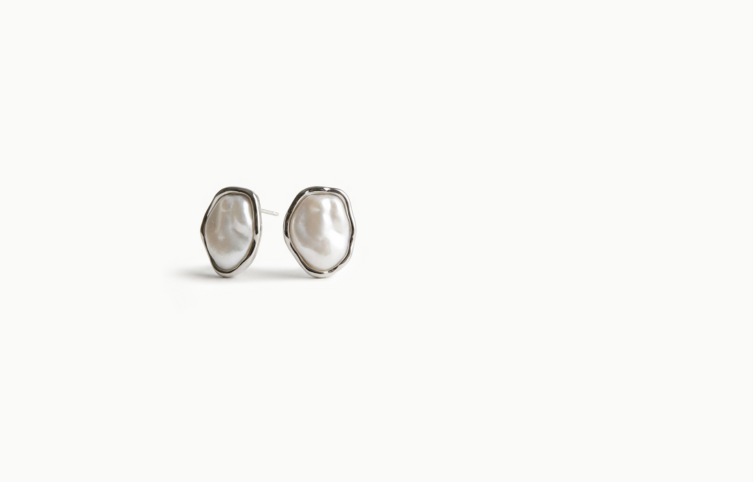 Irregular baroque pearl stud earrings framed in silver