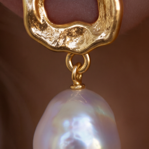 Molten Pearl drop earrings, macro of textured gold above a white pearl drop
