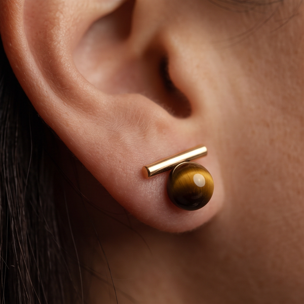 Wood Orb Bar stud earrings worn on the ear, gold bar above a round brown bead