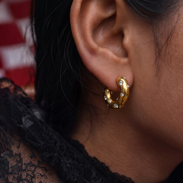 Chunky Spot crystal hoop earrings worn on the ear, gold hoop dotted with crystals, black lace top