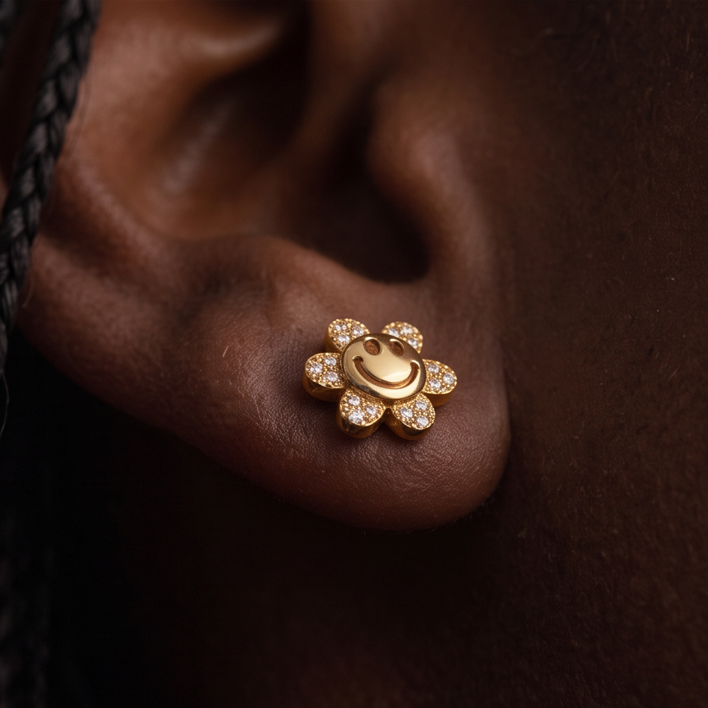 Flower Power stud earrings, close-up of a gold smiley face flower with crystal petals on the ear
