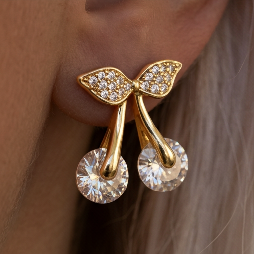 Crystal Cherry earrings close-up on the ear, round crystals hanging from gold stems and leaves
