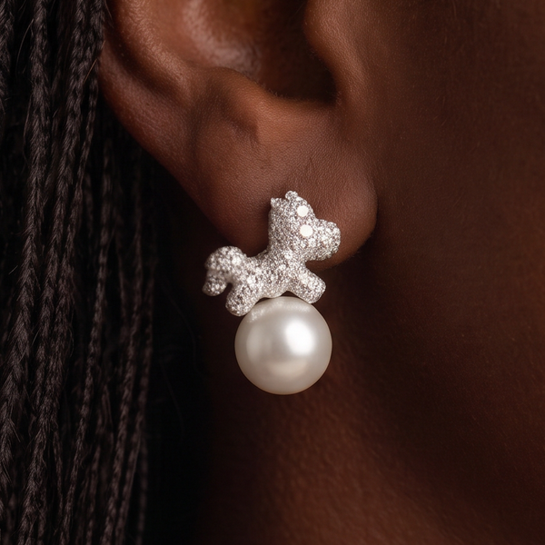 Crystal Carousel Pearl earrings close-up on the ear, crystal-covered silver horse resting on a white pearl