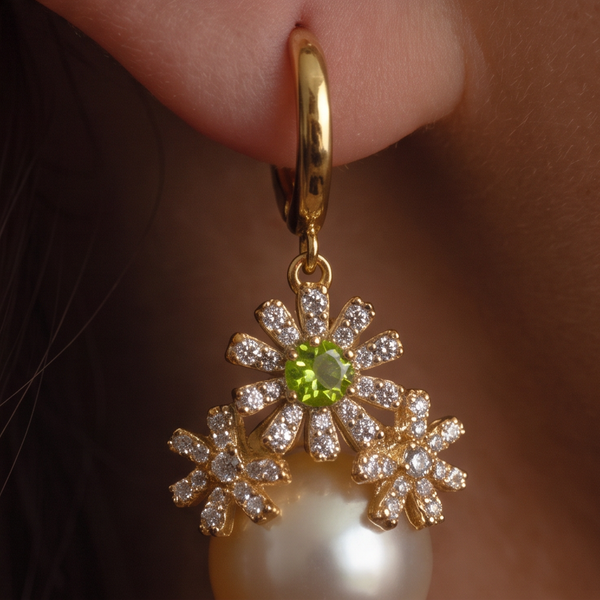 Garden Party crystal pearl earrings close-up, crystal daisies with a green center jewel above a cream pearl