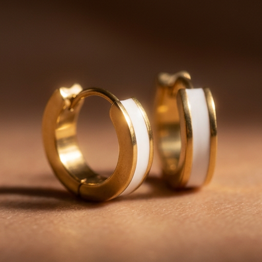 Meringue small hoop earrings, a pair of gold hoops with white center bands standing upright, close-up