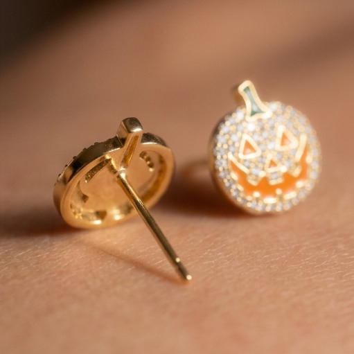 The Great Crystal Pumpkin earrings, a crystal-covered pumpkin stud with an orange carved face beside its back