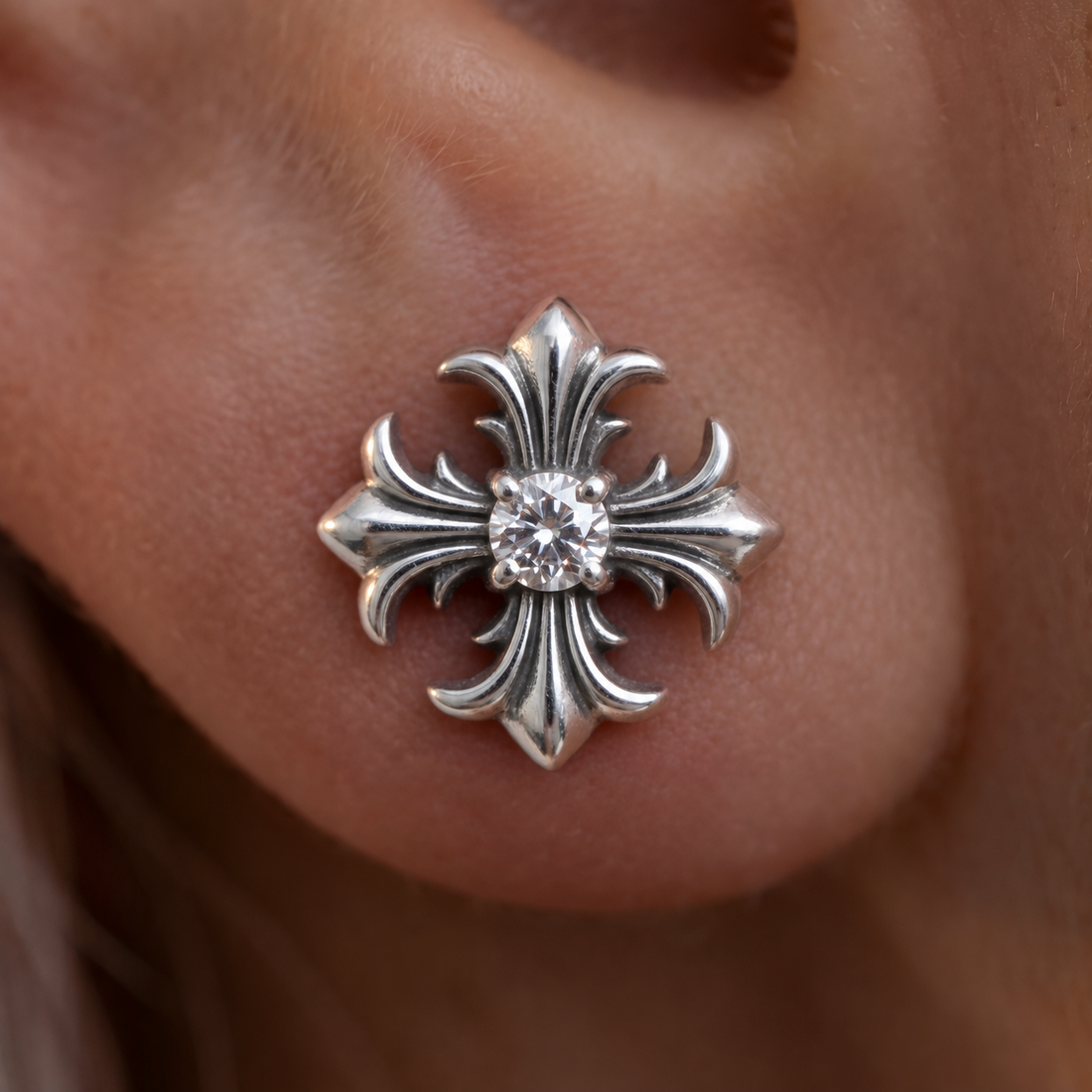 Fleur Cross crystal stud earring worn on the ear, silver cross with a round crystal in the center