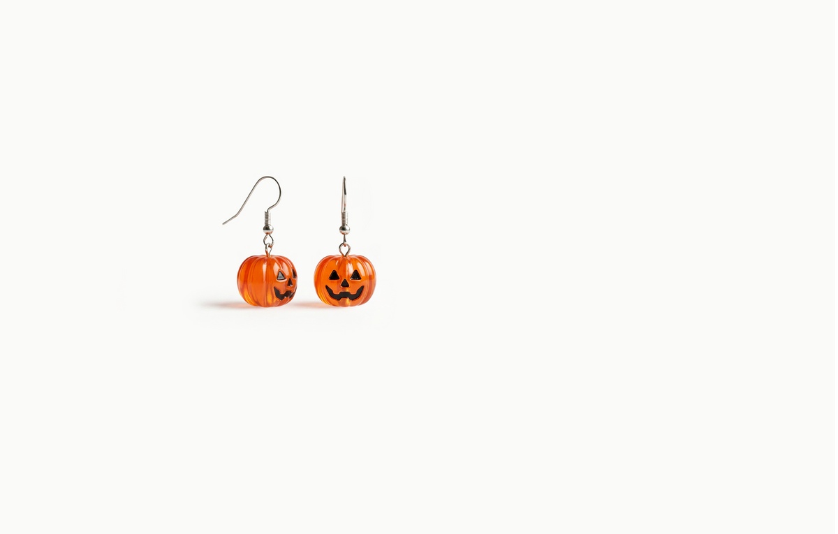 Translucent orange pumpkin drop earrings with a jack-o'-lantern face