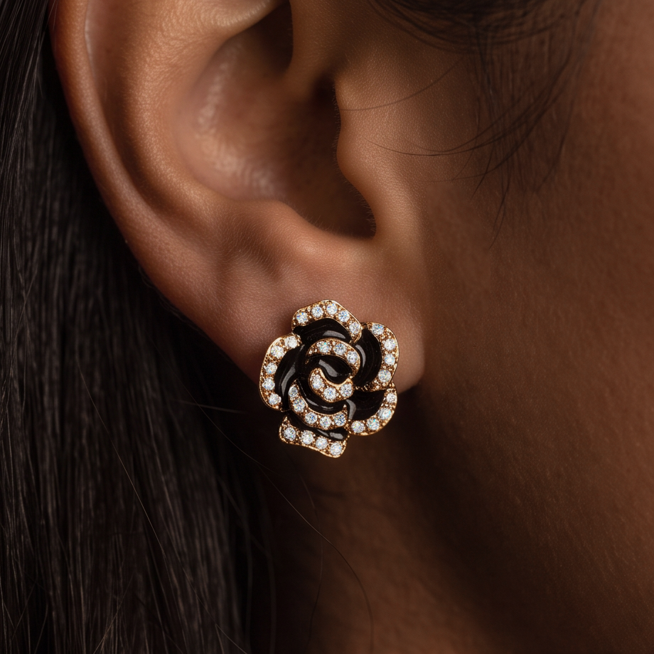 Black Rose crystal stud earring close-up on the ear, black petals outlined with crystals, dark hair behind