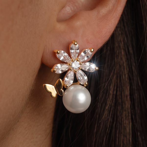 Crystal Flower Pearl earrings worn on the ear, crystal flower with a gold butterfly above a large pearl