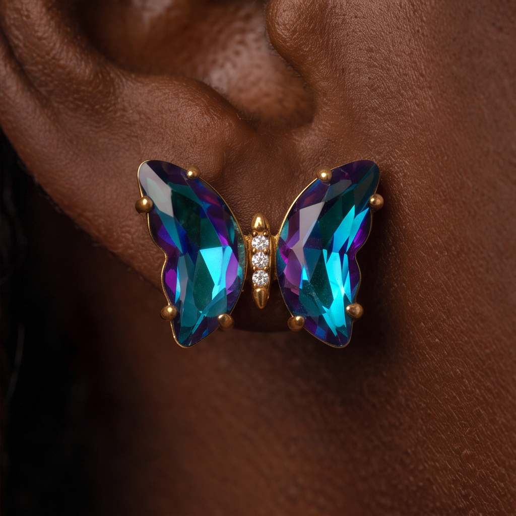 Nebula Crystal Butterfly earring worn on the ear, close-up of teal and purple crystal wings