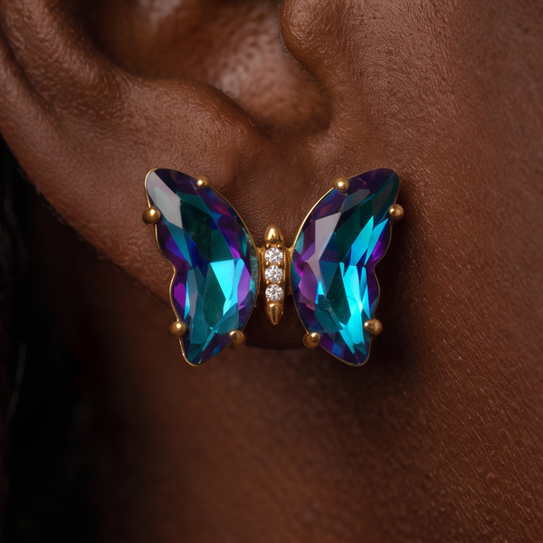 Nebula Crystal Butterfly earring worn on the ear, close-up of teal and purple crystal wings