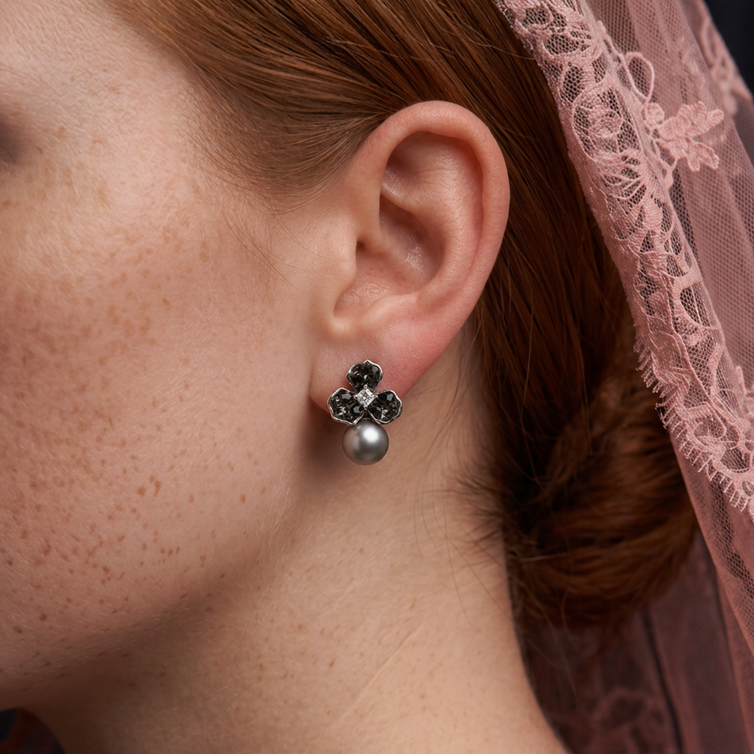 Crystal Chrome Pearl earring worn on the ear, dark crystal flower with a grey pearl, pink lace veil