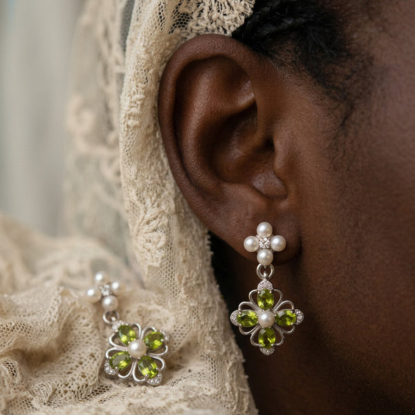 Victorian Crystal Drop earring worn on the ear, pearl cluster above a green jewel flower, cream lace behind