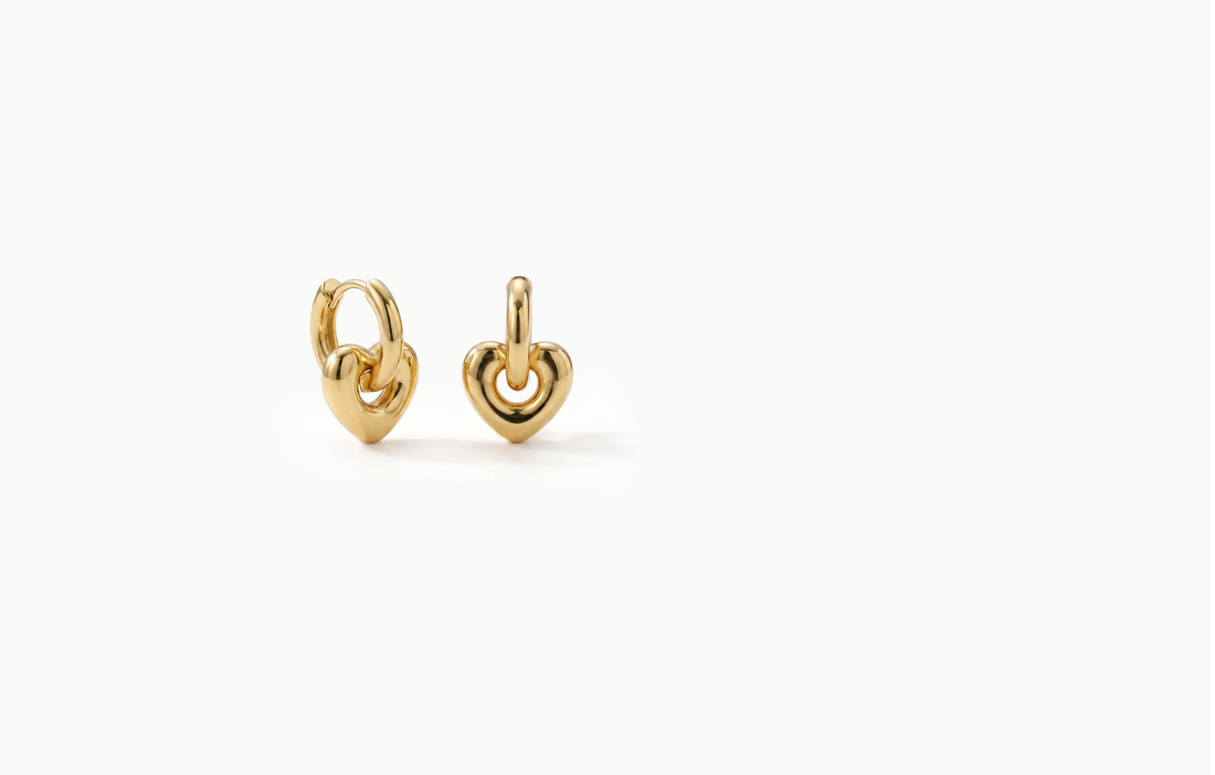 Gold drop earrings with a rounded heart hanging from a hoop
