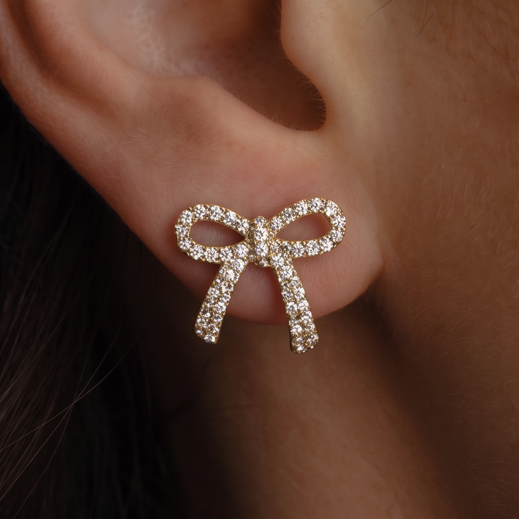 Crystal Bow stud earring worn on the ear, extreme close-up of tightly set crystals on the gold bow