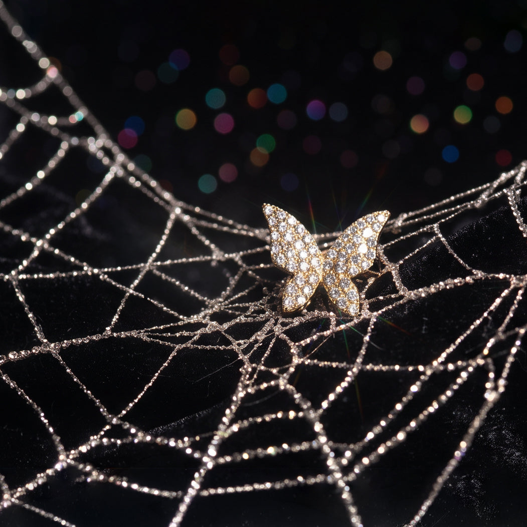 Honey Butterfly ear cuff on dark velvet over a sparkling spider web, gold butterfly covered in crystals