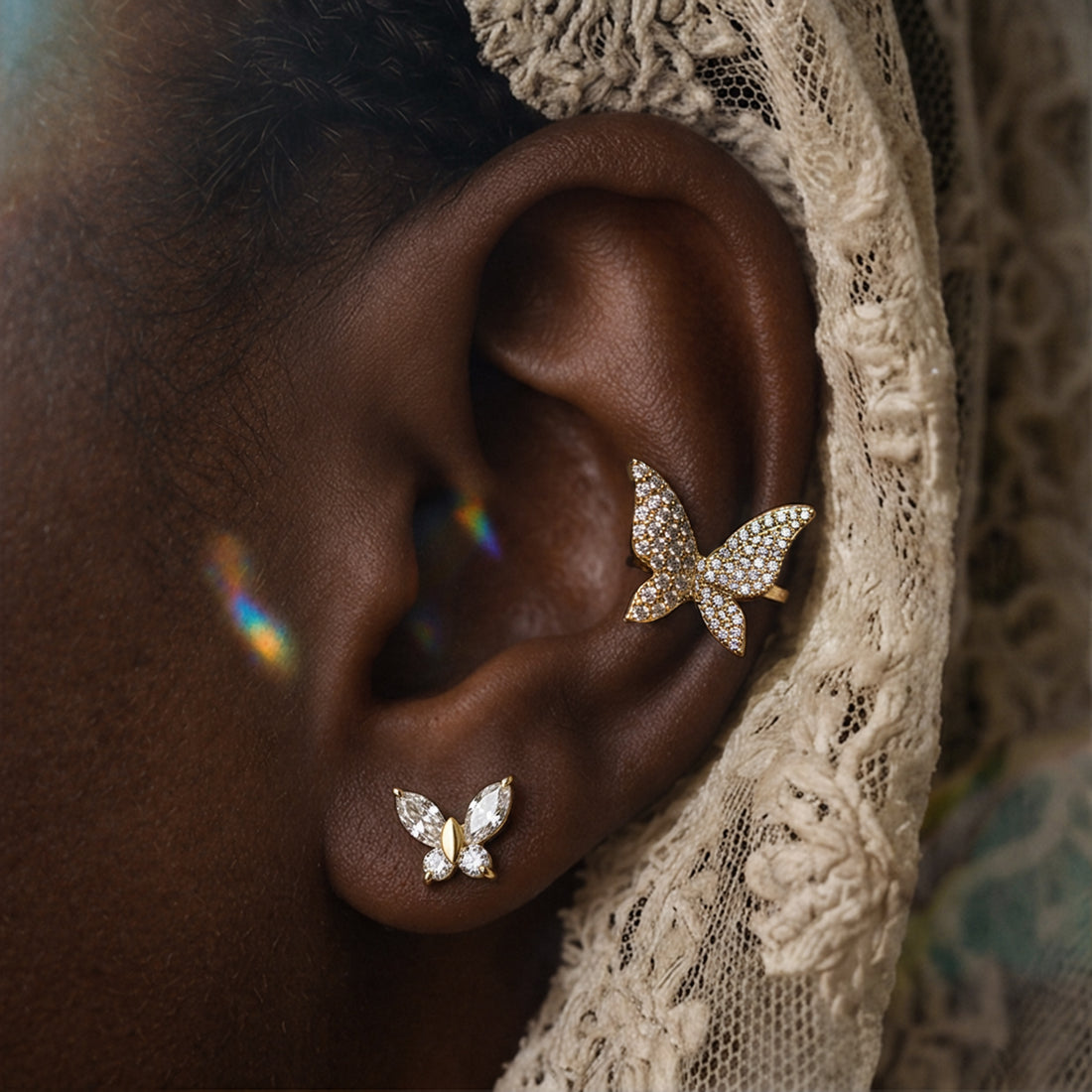 Honey Butterfly ear cuff worn on the ear above a small crystal butterfly stud, cream lace veil behind