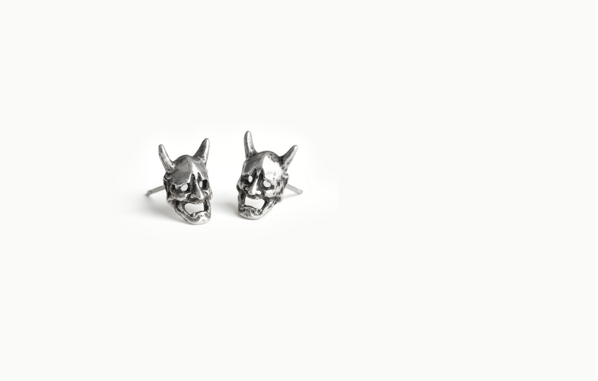 Devil Mask stud earrings; a pair of silver horned masks with open mouths on a white background