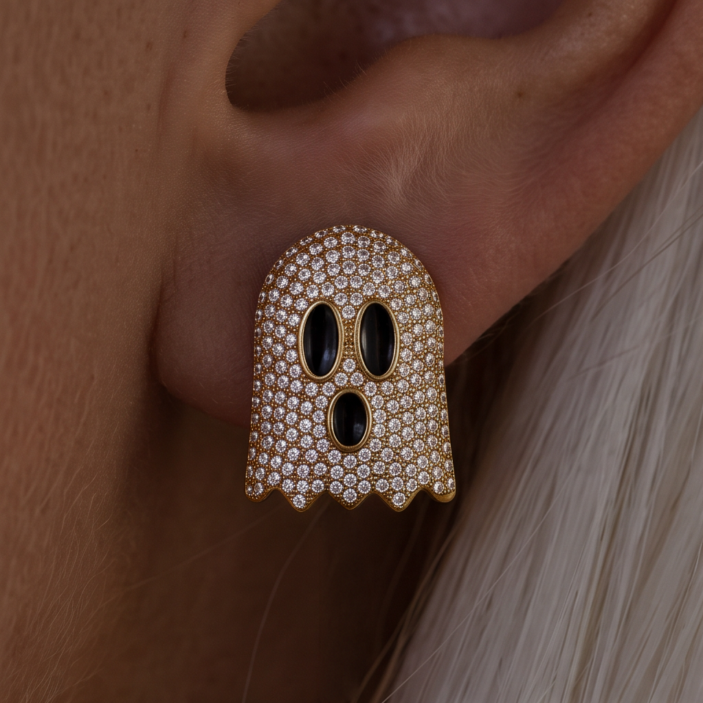 Crystal Boo earrings worn on the ear, a gold ghost covered in crystals with three black eyes